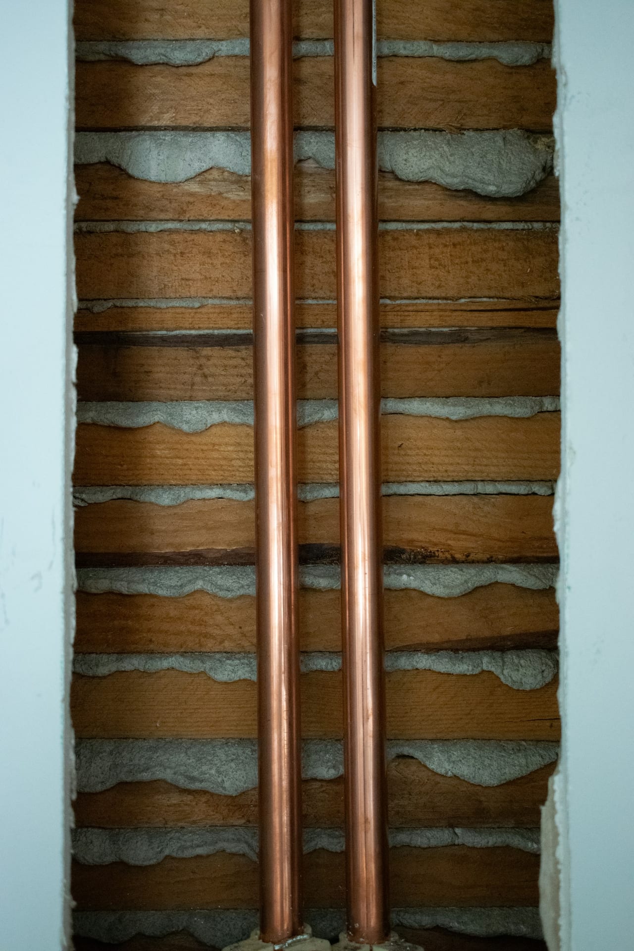 Copper pipes visible through an opened interior wall